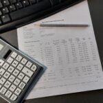 Taschenrechner neben Tatstatur und Berechnung von Betriebskosten. Frist für 2024 ist der 31.12.2025